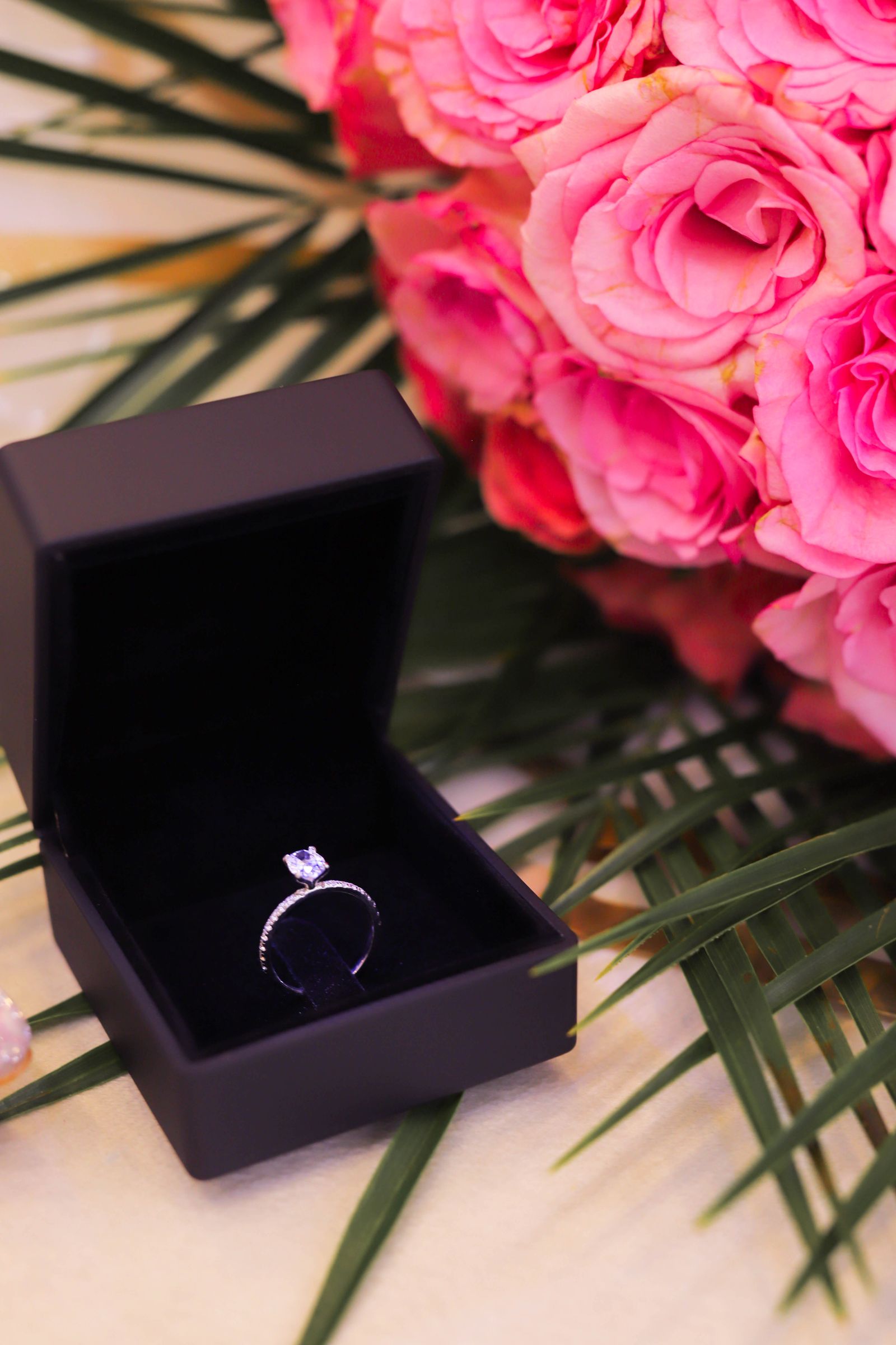 Diamond ring in a black gift box with flowers