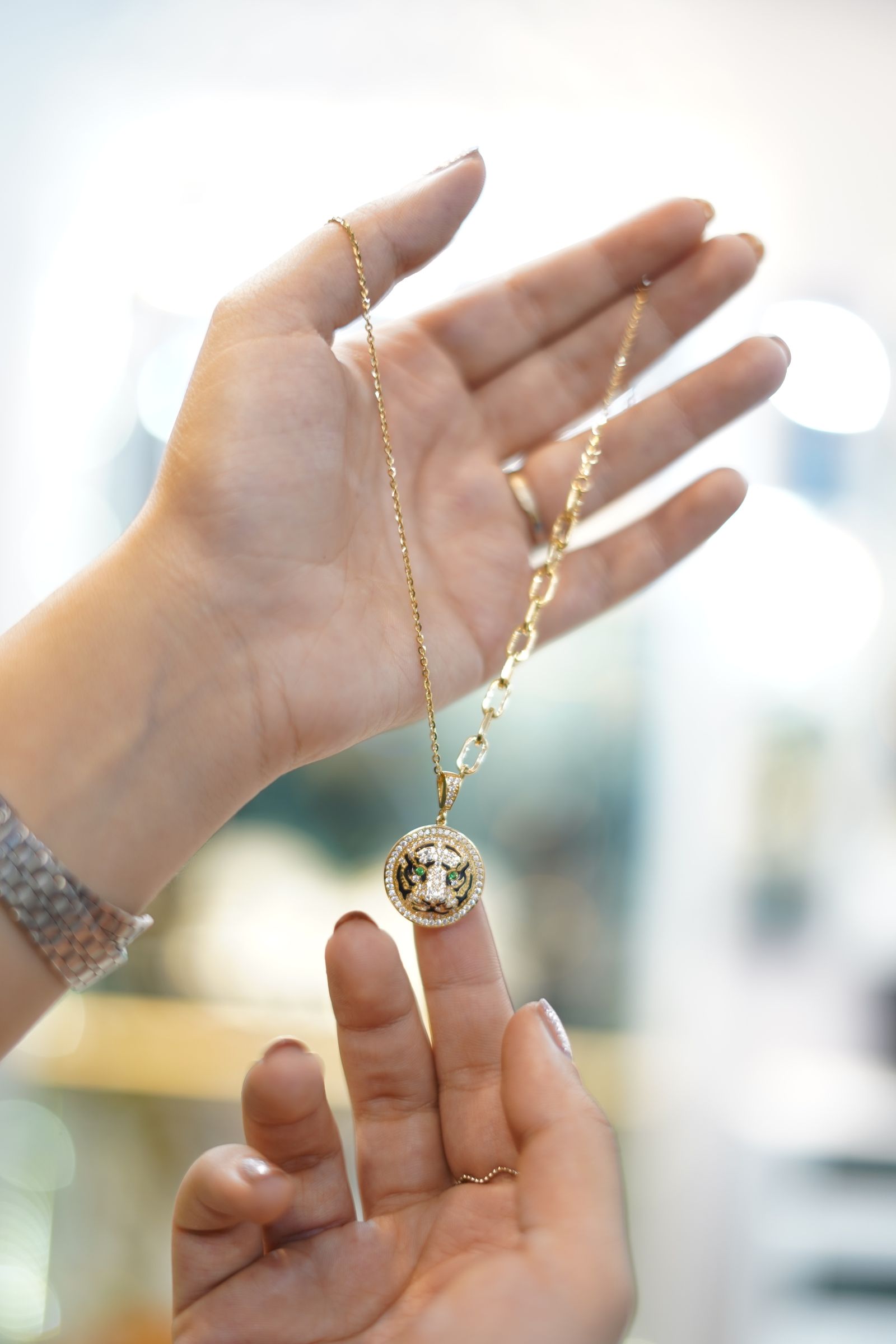 Hands holding a gold pendant